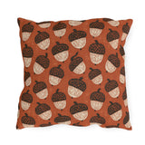 Block-printed cream and dark brown acorns on rust orange outdoor pillow