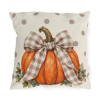 Orange pumpkin with a taupe gingham bow and eucalyptus on a cream polka dot outdoor pillow