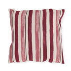 Cranberry and rose painted stripes on a cream outdoor pillow