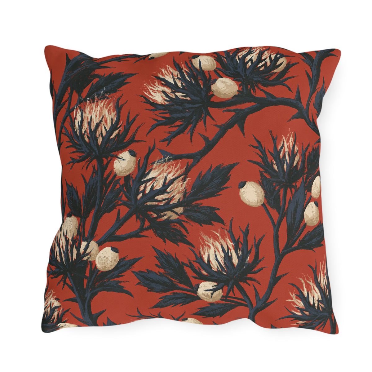Navy sea holly thistles with cream heads on a brick red outdoor pillow