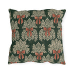 Cream foliage sprays tied with clay bows on a deep forest green outdoor pillow