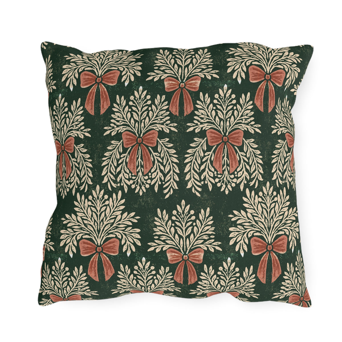 Cream foliage sprays tied with clay bows on a deep forest green outdoor pillow