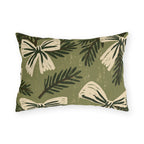 Cream bows and dark spruce sprigs on a soft sage green outdoor lumbar pillow