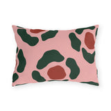 Modern outdoor lumbar pillow with forest green and rust red abstract rosettes on blush pink