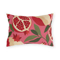 Modern outdoor lumbar pillow with cream and red pomegranates and green leaves on bright pink