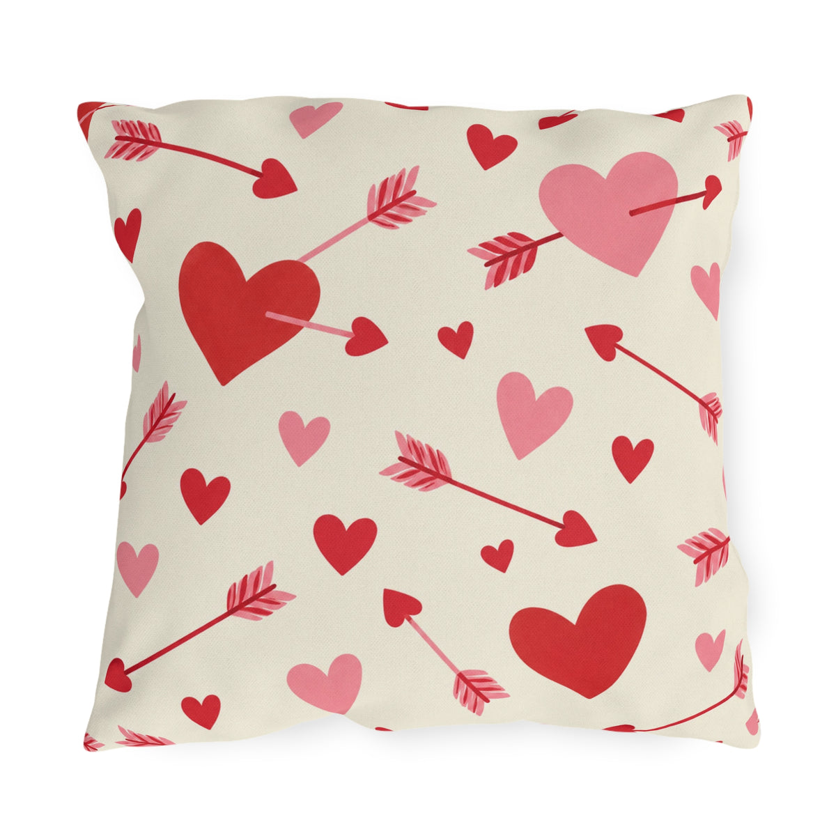 Valentine's outdoor pillow with red and pink cupid arrows and hearts on cream