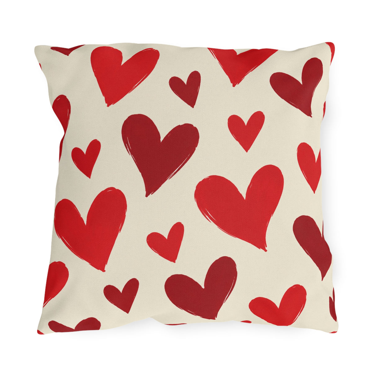 Valentine's outdoor pillow with hand-painted red hearts tossed across cream