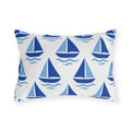 Coastal outdoor lumbar pillow with rows of cobalt and sky blue sailboats and waves on white