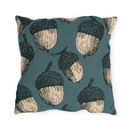 Oversized cream and black block print acorns on a deep teal outdoor pillow