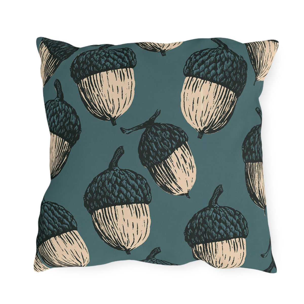 Oversized cream and black block print acorns on a deep teal outdoor pillow