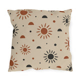 Boho outdoor pillow with rust and charcoal hand-drawn suns and half circles on light sand