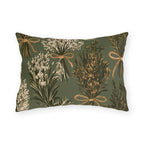 Rosemary, lavender and thyme bundles tied with twine on a sage green outdoor lumbar pillow