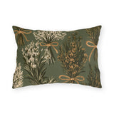 Rosemary, lavender and thyme bundles tied with twine on a sage green outdoor lumbar pillow