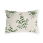 Green outdoor lumbar pillow with sage green eucalyptus sprigs tied with ribbon bows on cream