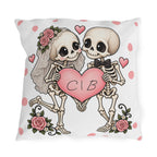 Personalized skeleton bride and groom holding a pink heart with custom initials, on a white polka dot outdoor pillow