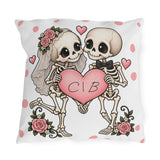 Personalized skeleton bride and groom holding a pink heart with custom initials, on a white polka dot outdoor pillow