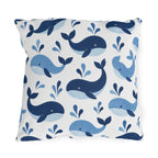 Coastal outdoor pillow with tossed navy and sky blue whales with water spouts on white