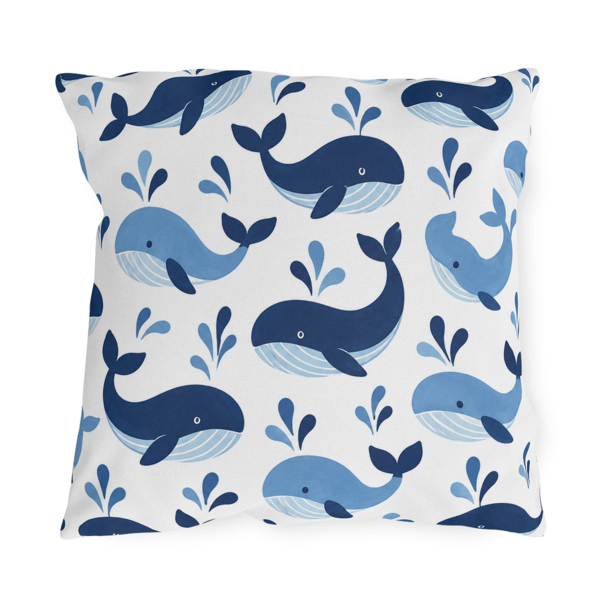 Coastal outdoor pillow with tossed navy and sky blue whales with water spouts on white