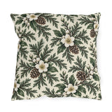White winter roses, cedar, pinecones and white berries on a cream outdoor pillow