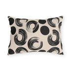 Black brush rings and solid dots on an oatmeal outdoor lumbar pillow