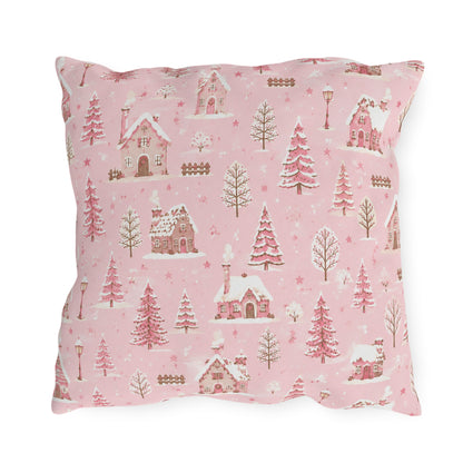Snow-covered pink cottages and fir trees on pink outdoor pillow