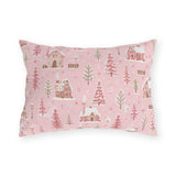 Snow-covered pink cottages and fir trees on pink outdoor lumbar pillow