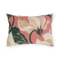 Floral outdoor lumbar pillow with large painted cream cyclamen flowers and dark green leaves on coral pink