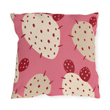 Modern outdoor pillow with cream and cherry red prickly pear cactus pads on bright pink
