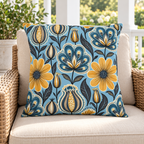 Blue and mustard folk flower outdoor pillow styled on patio furniture