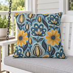 Blue and mustard folk flower outdoor pillow styled on a porch