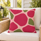 Pink and olive pebble outdoor pillow styled on patio furniture