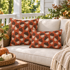 Block-printed acorn outdoor pillows in rust orange styled together on a porch