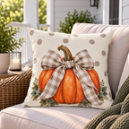 Pumpkin bow outdoor pillow styled on a wicker porch sofa with a lantern and greenery