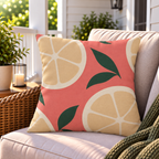 Coral citrus slice outdoor pillow styled on patio furniture
