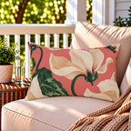 Coral cyclamen floral outdoor lumbar pillow styled on patio furniture