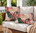 Coral cyclamen floral outdoor pillow and outdoor lumbar pillow styled together as a set