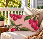 Pink berry outdoor lumbar pillow styled on patio furniture
