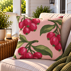 Pink berry outdoor pillow styled on patio furniture