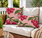 Pink berry outdoor pillow and outdoor lumbar pillow styled together as a set