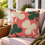 Coral clover leaf outdoor pillow styled on patio furniture