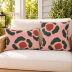 Pink and green abstract rosette outdoor pillow and outdoor lumbar pillow styled together as a set
