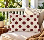 Merlot polka dot outdoor lumbar pillow styled on patio furniture