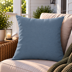 Solid dusty blue outdoor pillow styled on patio furniture