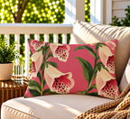 Pink foxglove floral outdoor lumbar pillow styled on patio furniture