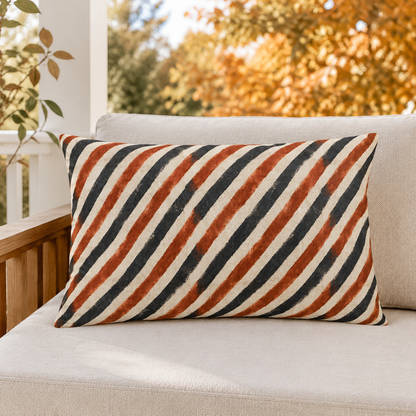 Diagonal rust and charcoal block-printed stripes on cream outdoor lumbar pillow