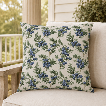 Blue juniper berries and green foliage on cream outdoor pillow