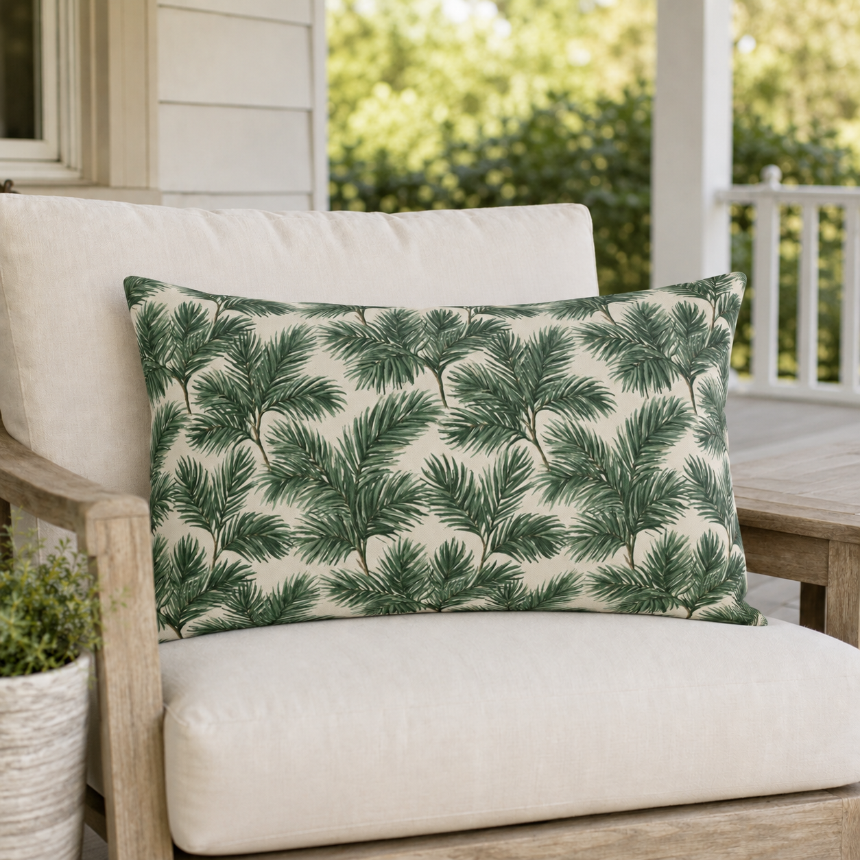 Deep green pine and fir branches on cream outdoor lumbar pillow
