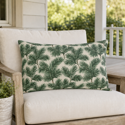 Deep green pine and fir branches on cream outdoor lumbar pillow