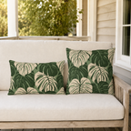 Cream and forest green monstera leaves on sage outdoor pillow
