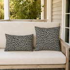 Hand-painted cream dots on charcoal outdoor lumbar pillow